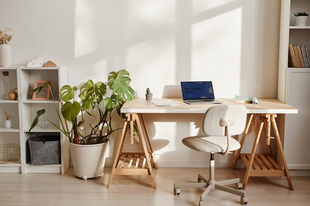 Imagem de fundo do interior de casa aconchegante com laptop na mesa e local de trabalho decorado com plantas e l...