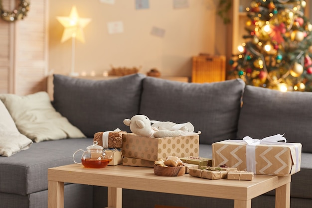 Imagem de fundo do interior de uma casa aconchegante com presentes de natal na mesa em primeiro plano, copie o espaço