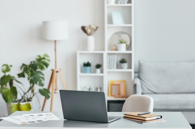 Imagem de fundo mínima do local de trabalho do escritório em casa com o laptop em um interior branco e arejado, copie o espaço