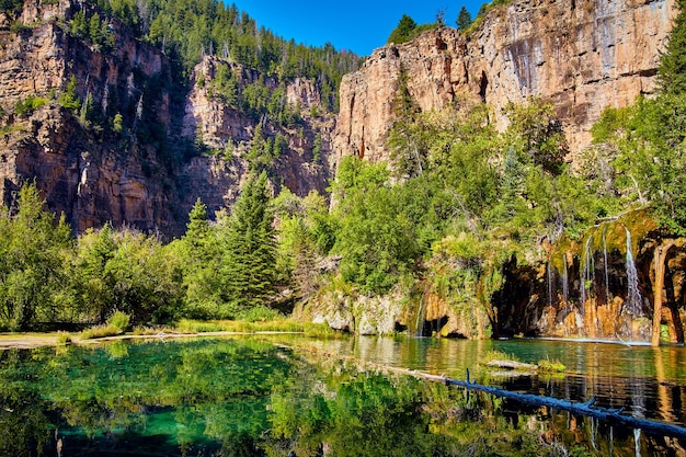 Imagem de grande vista da montanha ao lado do lago com cachoeira