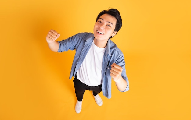 Imagem de homem asiático posando em um fundo amarelo