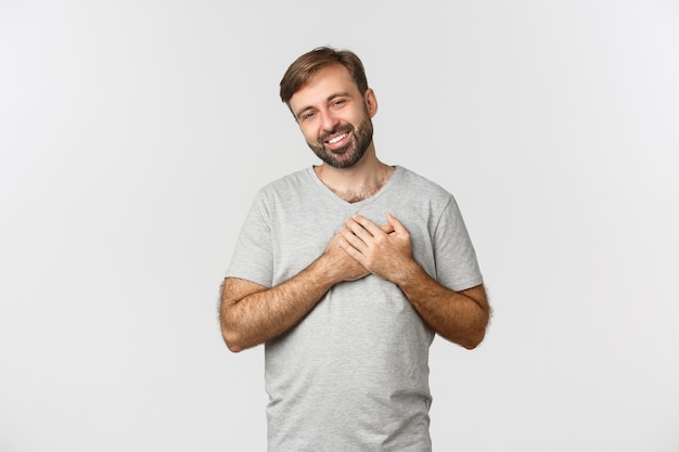 Imagem de homem bonito e gentil com barba, vestindo camiseta cinza
