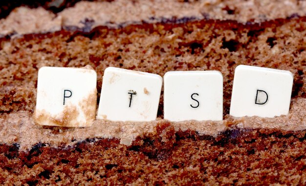 Foto imagem de letras de um teclado ptsd em um fundo de bolo de chocolate