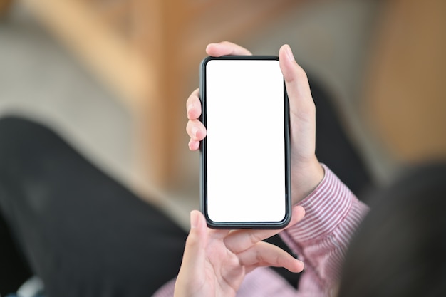 Imagem de mãos segurando o celular preto com tela em branco