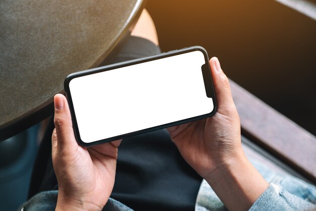 Imagem de maquete das mãos de uma mulher segurando um celular preto com uma tela em branco