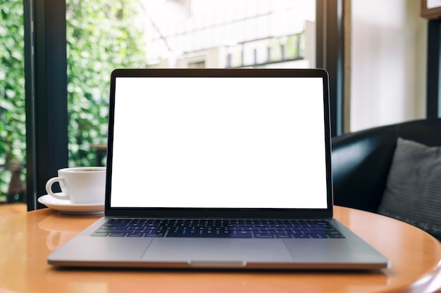 Imagem de maquete de computador laptop com tela de desktop em branco na mesa de madeira