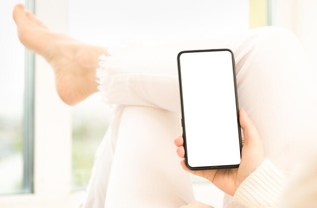 Imagem de maquete de mulher segurando o celular com tela branca em branco cliente usuário da mulher segura maquete de celular com tela branca na mão