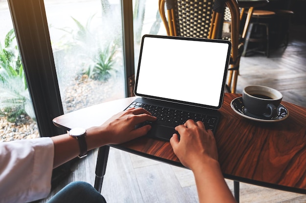 Imagem de maquete de uma mulher digitando no teclado do tablet com a tela em branco da área de trabalho como um PC com uma xícara de café na mesa