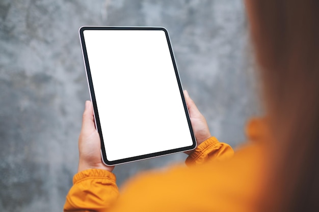 Imagem de maquete de uma mulher segurando o tablet digital com tela de desktop branca em branco ao ar livre