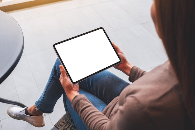 Imagem de maquete de uma mulher segurando o tablet digital com tela de desktop branca em branco