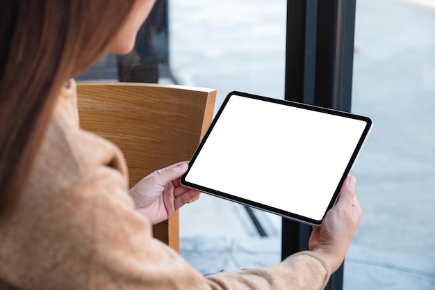 Imagem de maquete de uma mulher segurando o tablet digital com tela de desktop branca em branco