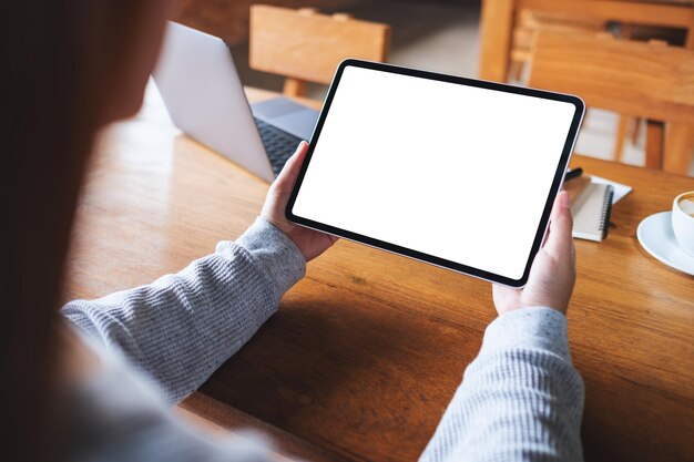 Imagem de maquete de uma mulher segurando o tablet digital com tela de desktop branca em branco