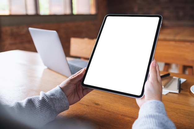 Imagem de maquete de uma mulher segurando o tablet digital com tela de desktop branca em branco