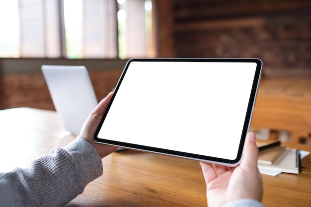 Imagem de maquete de uma mulher segurando o tablet digital com tela de desktop branca em branco