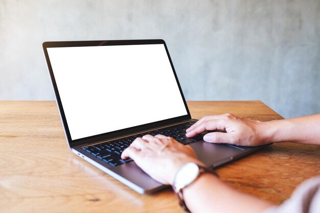 Imagem de maquete de uma mulher usando e digitando no laptop com tela branca em branco na mesa