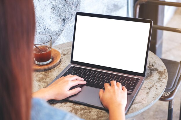 Imagem de maquete de uma mulher usando e digitando no teclado do computador portátil com tela branca em branco do desktop