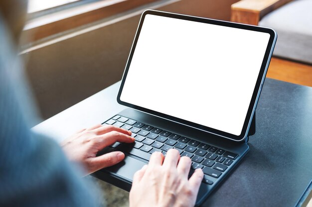 Imagem de maquete de uma mulher usando e digitando no teclado do tablet com a tela em branco da área de trabalho como um PC na mesa