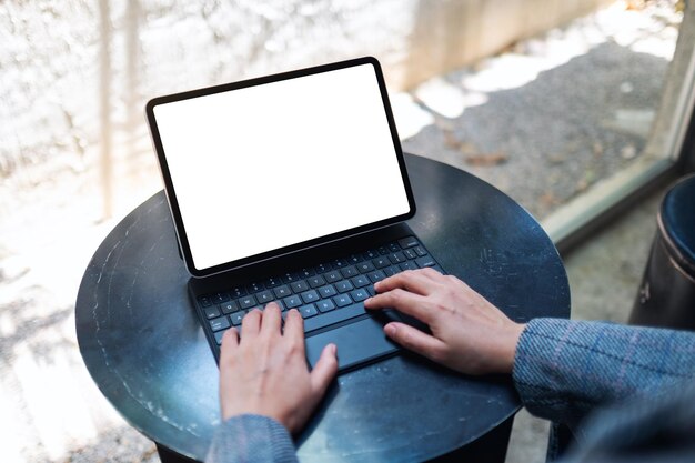 Imagem de maquete de uma mulher usando e digitando no teclado do tablet com a tela em branco da área de trabalho como um PC na mesa