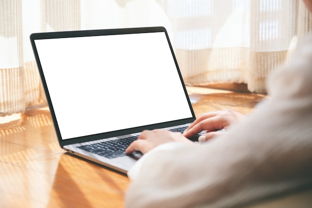 Imagem de maquete de uma mulher usando um laptop com uma tela em branco enquanto está deitada no chão sentindo-se relaxada