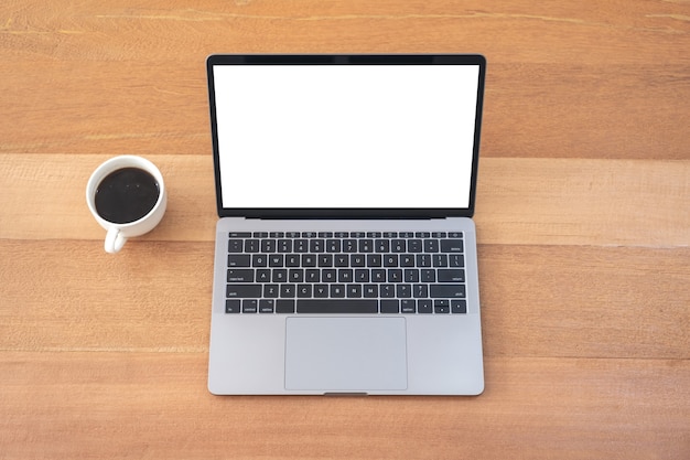 Imagem de maquete de vista superior de laptop com tela de desktop em branco e xícara de café na mesa de madeira