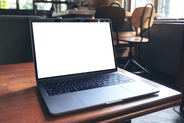 Imagem de maquete do laptop com tela branca em branco na mesa de madeira