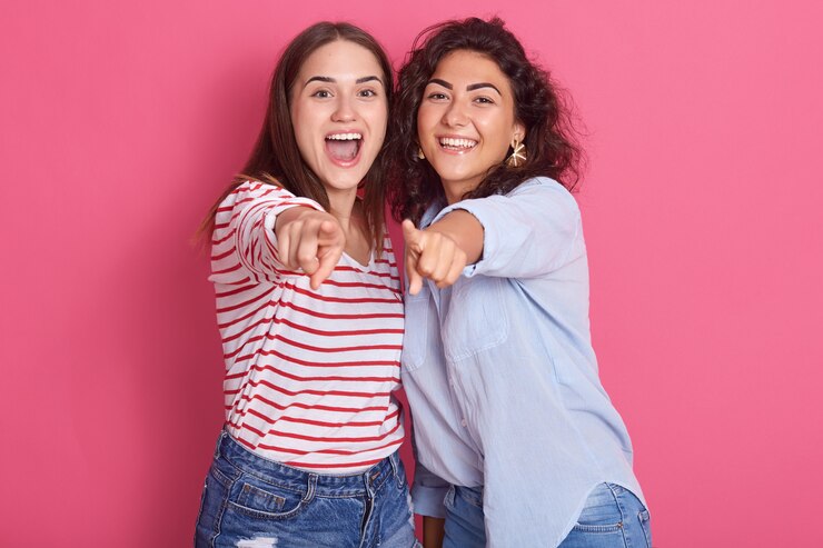 Foto imagem de meninas morenas sorridentes posando isolado sobre o estúdio rosa