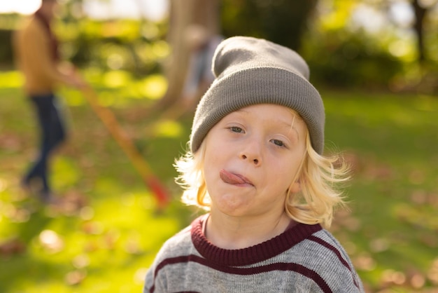 Imagem de menino caucasiano feliz fazendo caretas no jardim