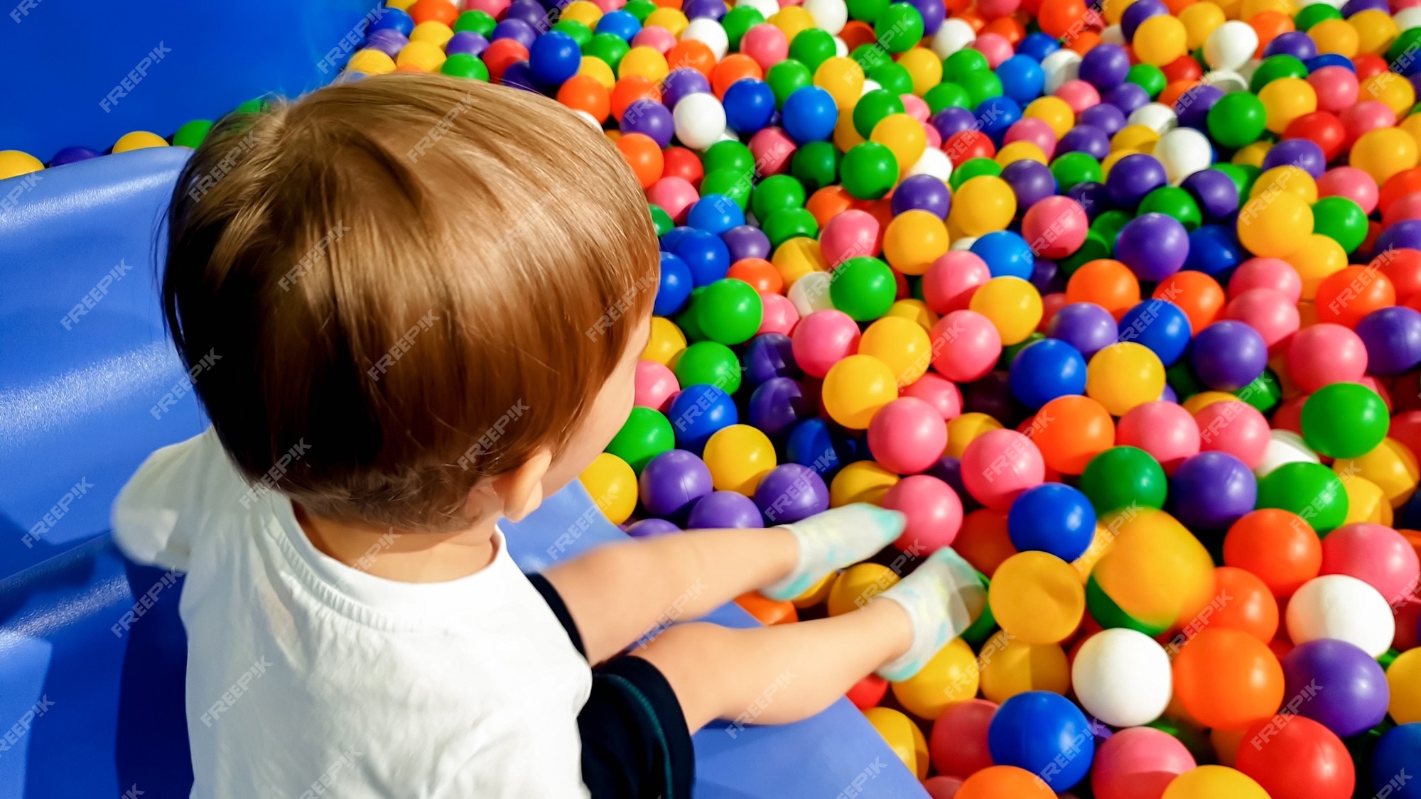 Menino Feliz Que Ri 1-2 Anos De Idade Que Se Diverte No Poço Da Bola Na  Festa De Aniversário No Parque De Diversões Das Crianças E No Centro Indoor  Do Jogo. Criança