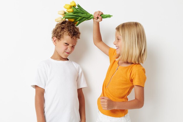 Imagem de menino e menina positivos divertidos presentes de aniversário surpresa buquê de flores estilo de vida inalterado