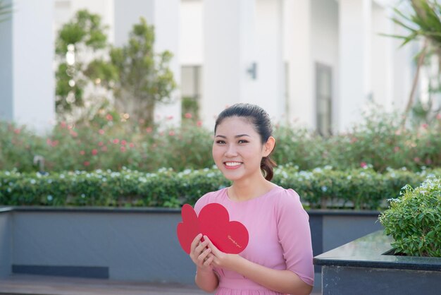 Imagem de mulher bonita feliz lendo cartão postal romântico com grande coração vermelho, mulher atraente com cartão sensual, dia dos namorados, conceito de amor