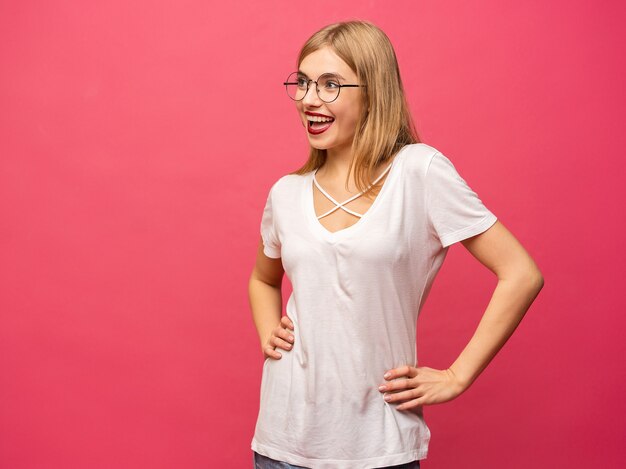 Imagem de mulher jovem feliz isolada sobre fundo rosa. Olhando a câmera apontando.