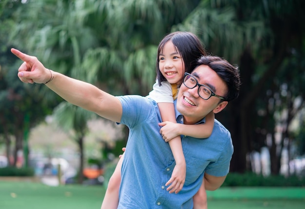 Imagem de pai e filha asiáticos brincando juntos no parque