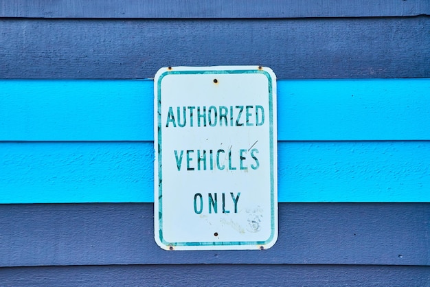 Imagem de painéis de madeira pintados de azul com a placa dizendo Somente veículos autorizados