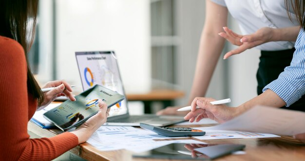 Foto imagem de parceiros de negócios discutindo documentos e ideias em uma reunião usando laptop e tablet digital