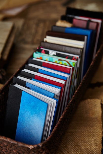 Imagem de pequenos livros multicoloridos dispostos ordenadamente em uma cesta