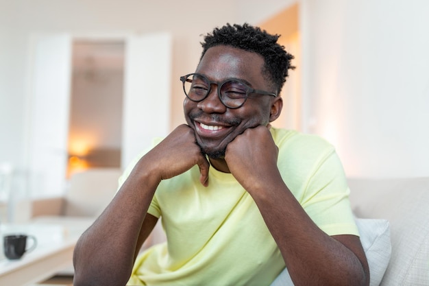 Imagem de perfil de sorridente jovem afro-americano de óculos posando no próprio apartamento em casa feche o retrato de tiro na cabeça de um feliz inquilino ou inquilino biracial milenar masculino em óculos mostram otimismo