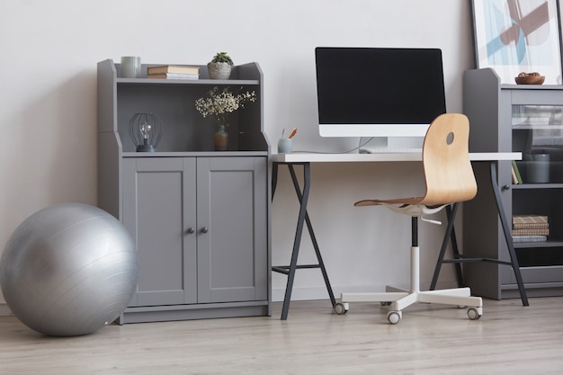 Imagem de plano de fundo do design mínimo de escritório em casa em tons de cinza e branco com bola de fitness, espaço de cópia