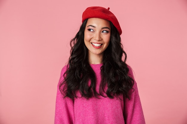 Imagem de positiva linda garota asiática com longos cabelos escuros usando boina sorrindo
