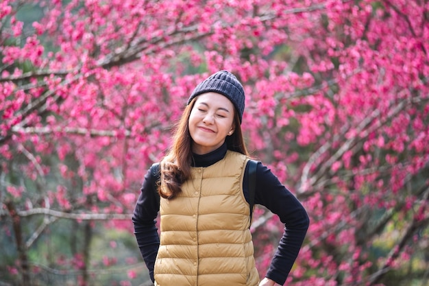 Imagem de retrato de uma bela jovem asiática com flor de cerejeira rosa no fundo