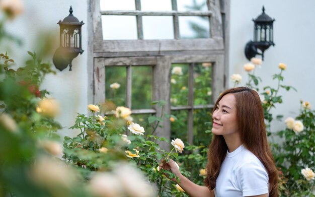 Imagem de retrato de uma bela jovem asiática no jardim de flores de rosas