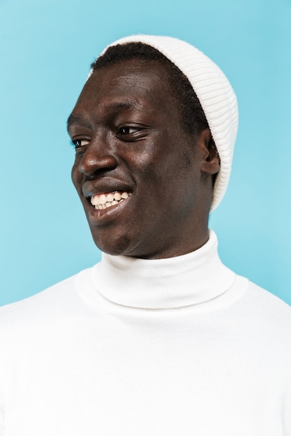 Imagem de um afro-americano feliz com roupas brancas, sorrindo e olhando para o lado