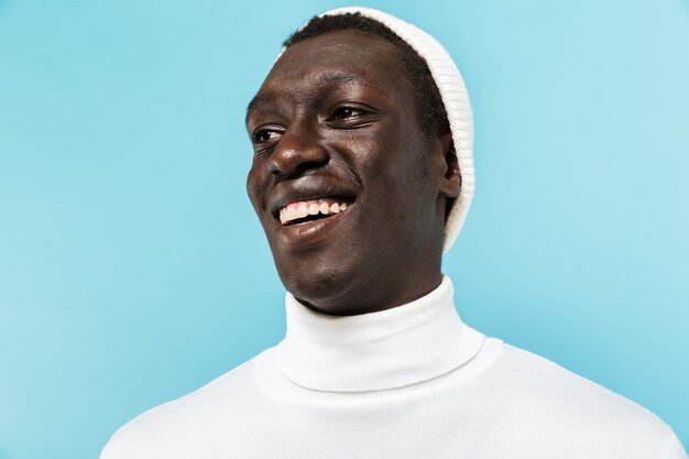 Imagem de um afro-americano feliz com roupas brancas, sorrindo e olhando para o lado