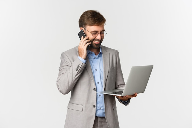 Imagem de um empresário de sucesso falando ao telefone e parecendo satisfeito no laptop