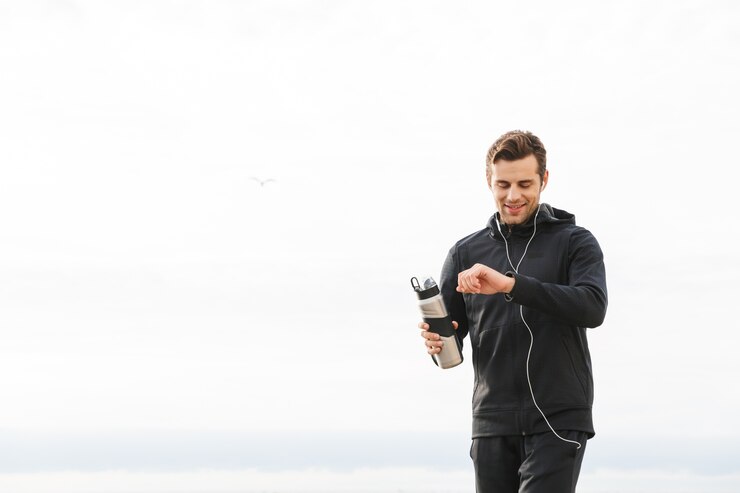 Foto imagem de um esportista dos anos 30 satisfeito com roupas esportivas pretas e fones de ouvido, fazendo exercícios e correndo à beira-mar