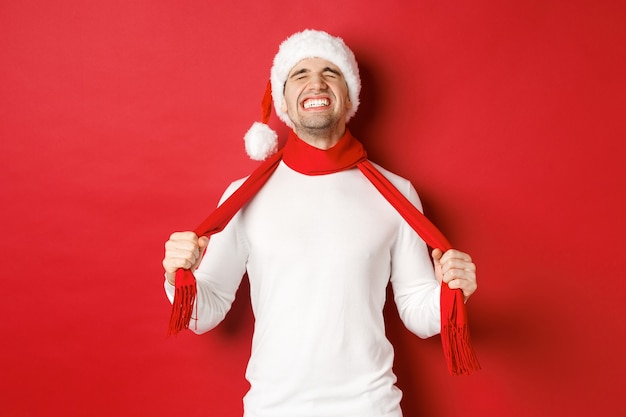 Imagem de um homem angustiado e frustrado com chapéu de Papai Noel se chocando com o lenço da tristeza ...