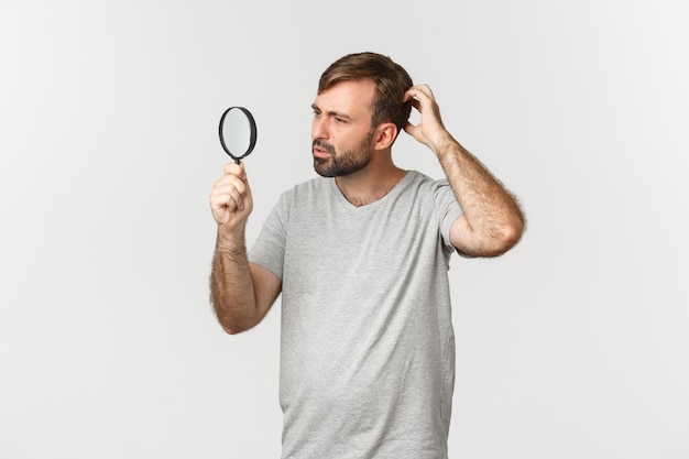 Imagem de um homem caucasiano bonito em uma camiseta cinza, procurando por algo