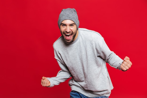 Imagem de um homem feliz dos 30 anos com a barba por fazer gritando e se alegrando isolada