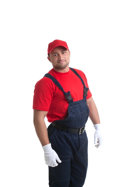 Imagem de um homem sorridente e musculoso posando em traje de trabalho