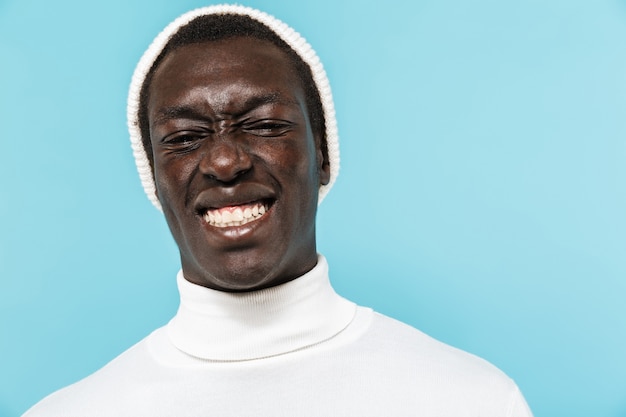 Imagem de um jovem afro-americano com roupas brancas, sorrindo e olhando
