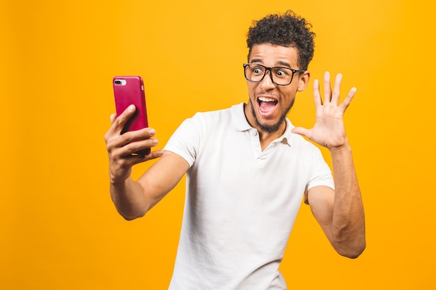 Imagem de um jovem afro-americano feliz posando isolado sobre um fundo amarelo